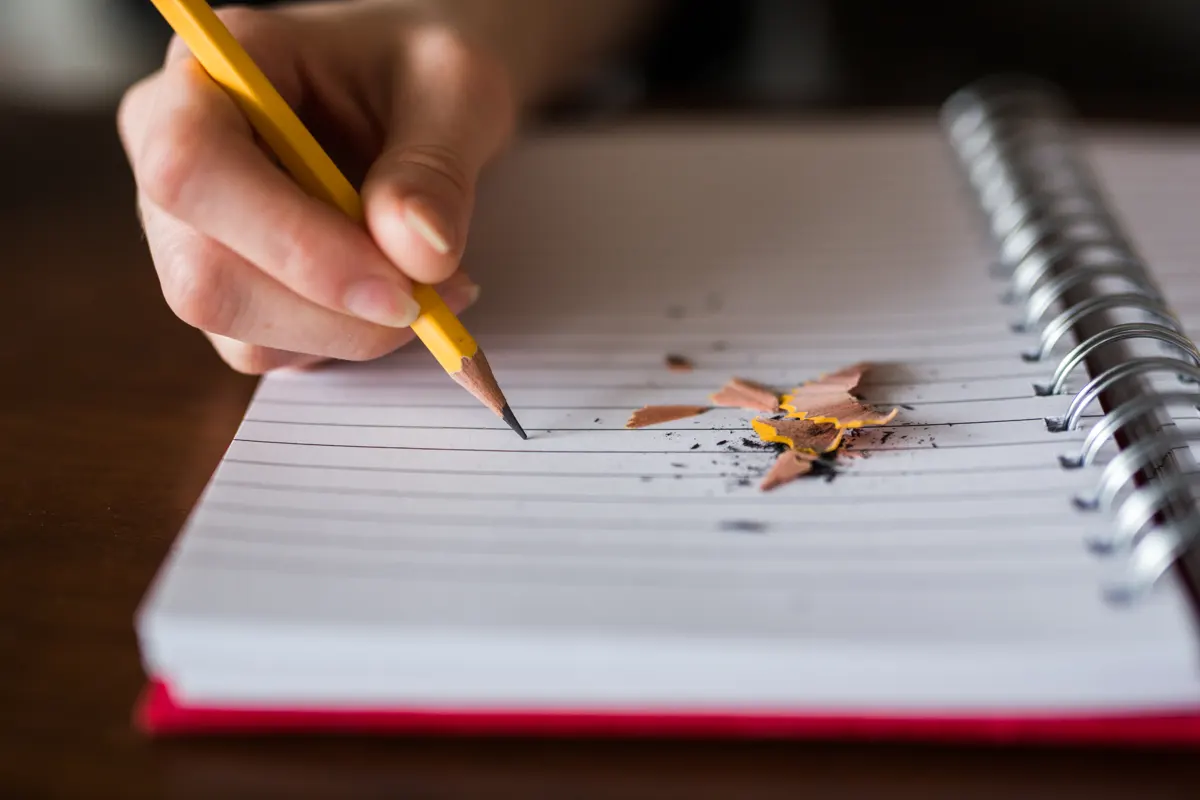 A hand writing with a pencil in a notebook, an illustration of planning